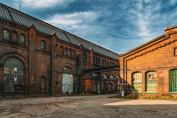 Brick railway or industrial buildings with arched windows around an open yard