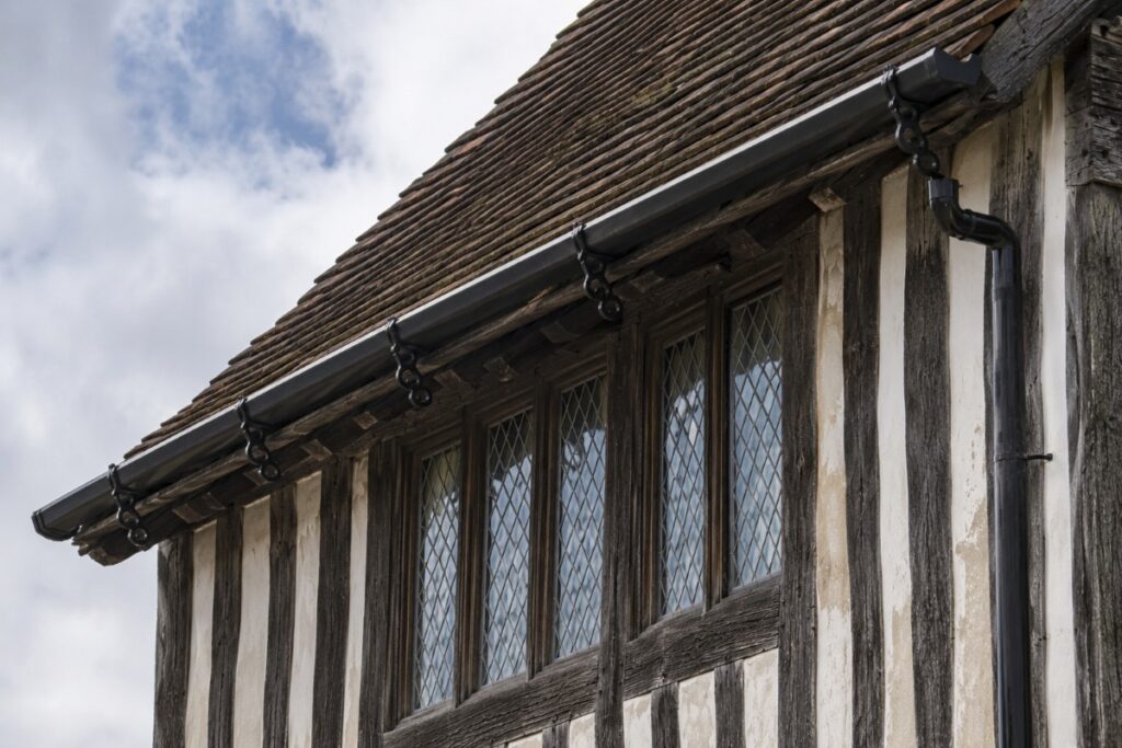 Cast iron gutter system shown on a Tudor building timber-framed house