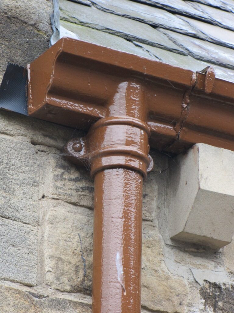 Cast iron downpipe with eared socket joints, red-oxide painted finish