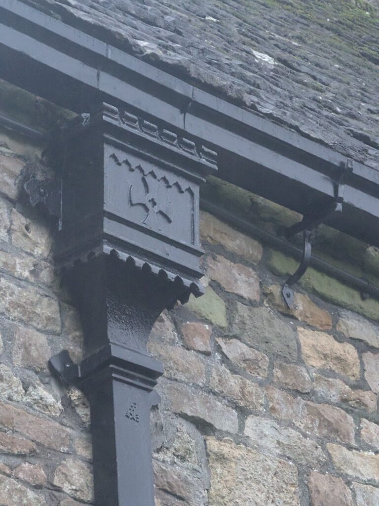 Detail of an ornamental cast iron gutter bracket on a church roofline