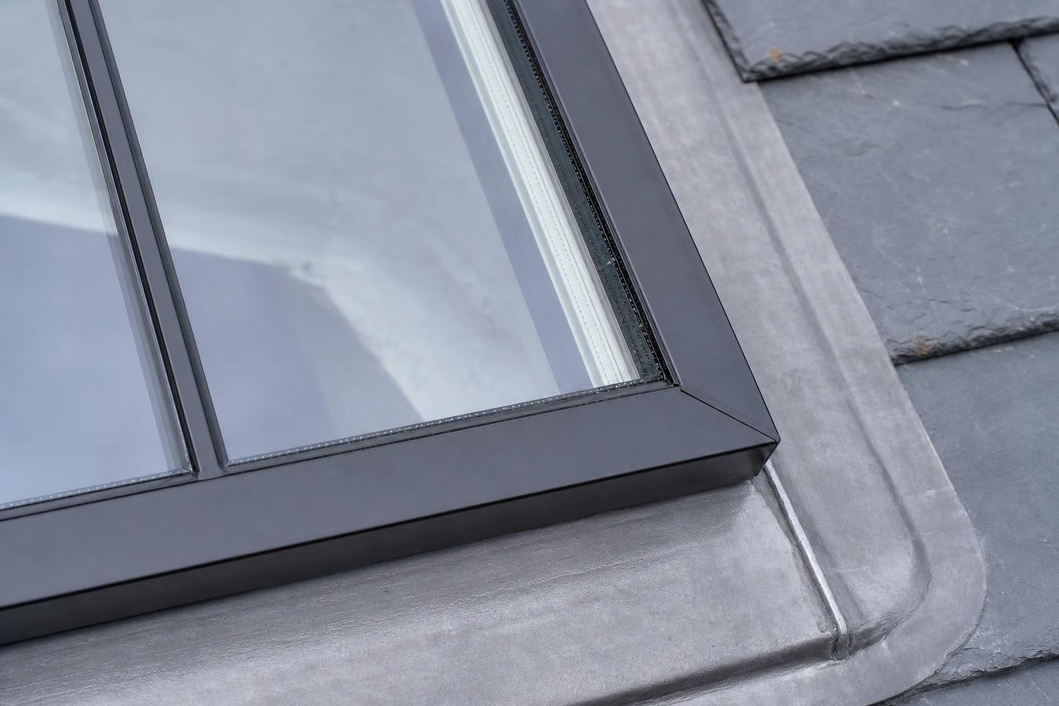 Close detail of a black steel conservation rooflight frame, central glazing bar and sealed double-glazed unit edge