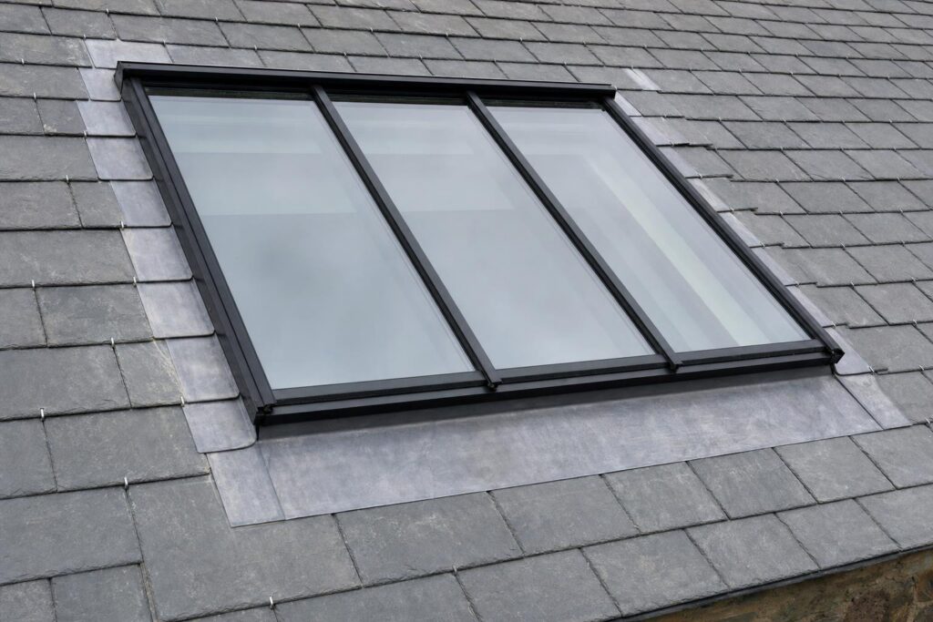 A conservation rooflight set into a slate roof with lead flashings dressed around the frame.