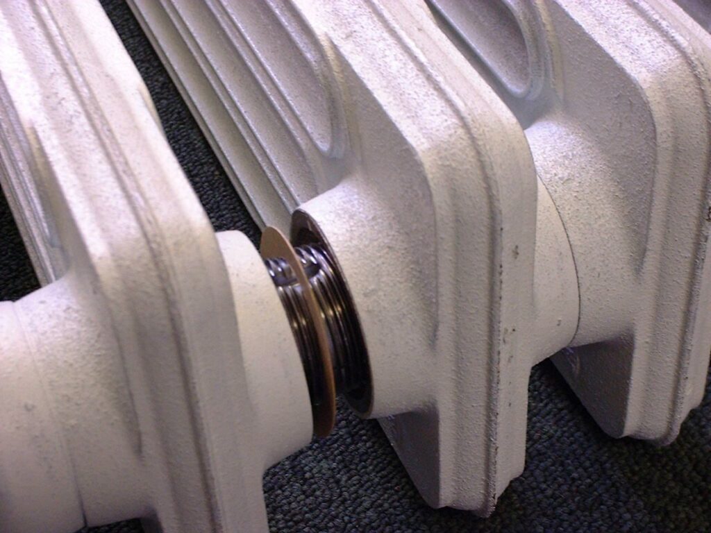 Cast iron radiator sections joined with threaded nipples during assembly