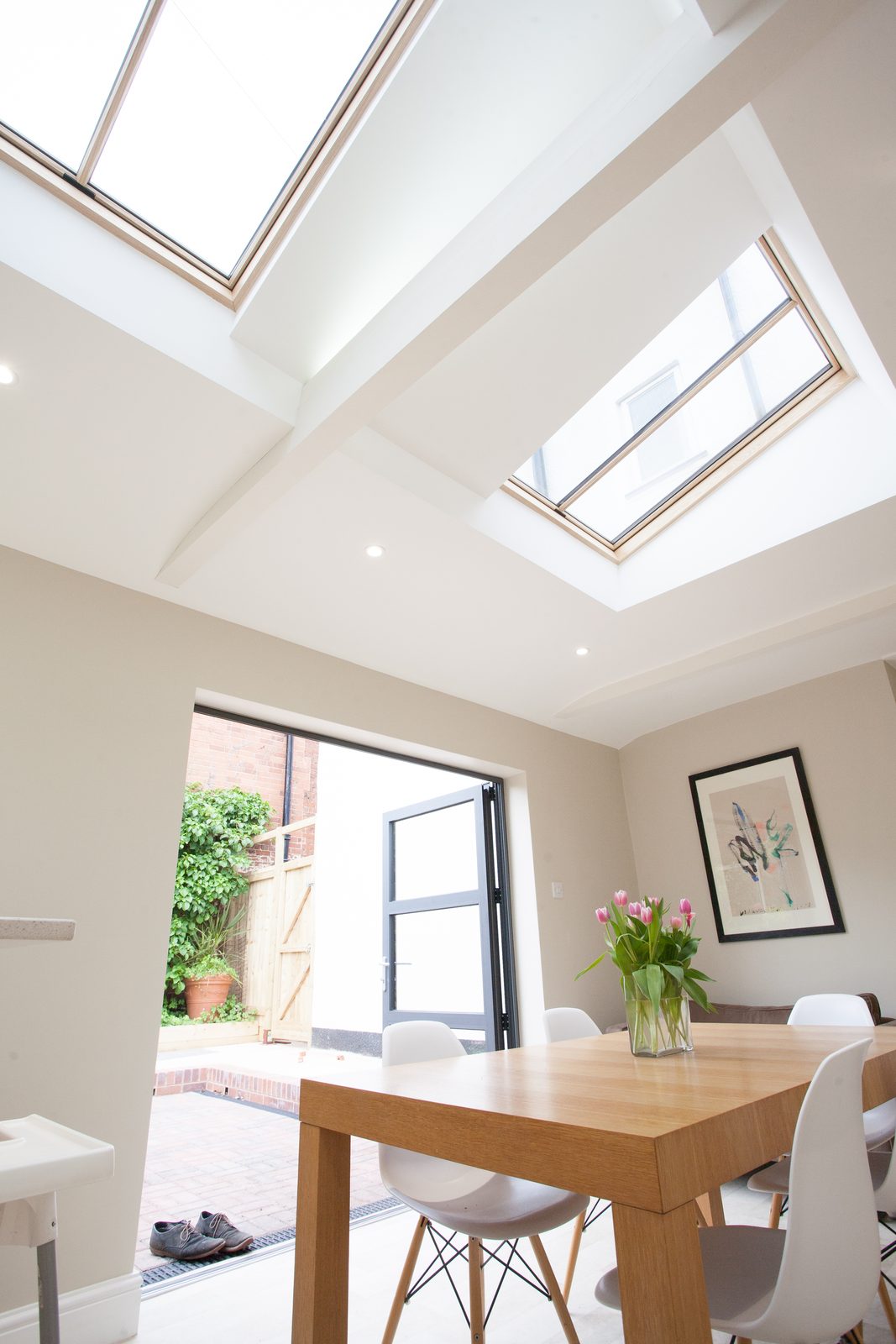 Bright kitchen and dining room lit by two conservation rooflights set in the sloping ceiling