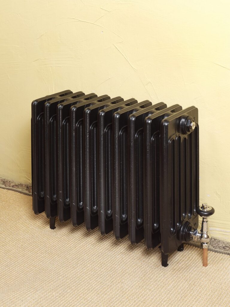 Six-column Victorian cast iron radiator in black with traditional valves
